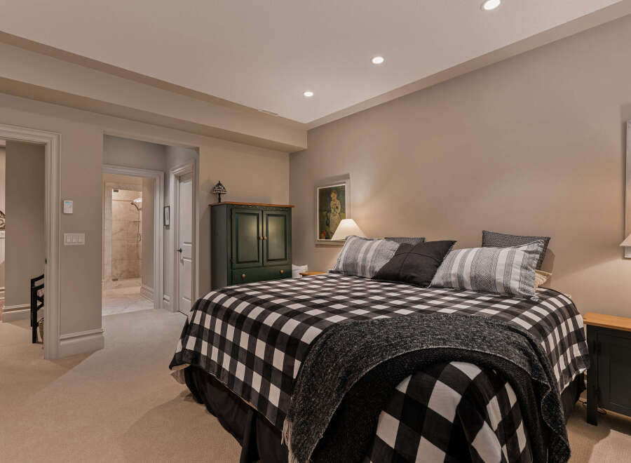 This inviting bedroom features a cozy king-sized bed adorned with a classic black and white buffalo check comforter and plush pillows.