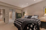 This inviting bedroom features a cozy king-sized bed adorned with a classic black and white buffalo check comforter and plush pillows.