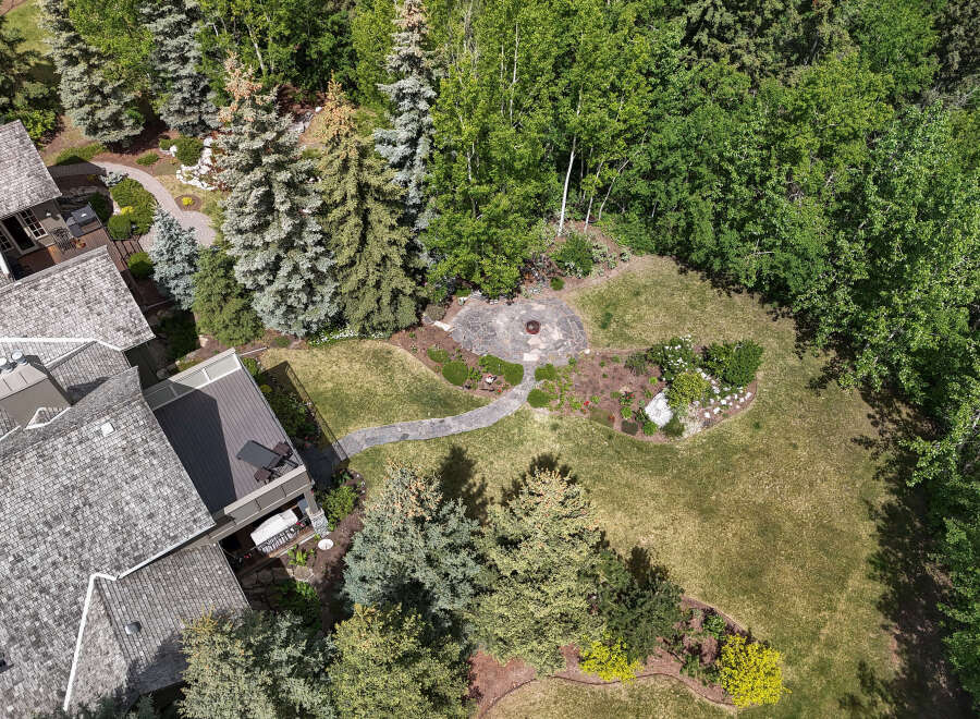 Discover this stunning property featuring a beautifully landscaped backyard with a stone patio and fire pit, perfect for outdoor entertaining.