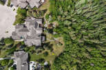 Experience luxury living in this stunning aerial view of a multi-level home featuring a distinctive grey shingle roof and expansive outdoor living spaces.