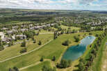 Discover luxury living in this stunning aerial view of a sprawling estate, featuring magnificent homes nestled amongst mature trees and manicured lawns.