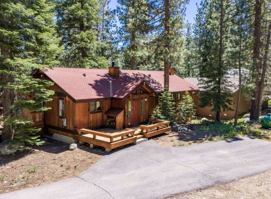 Nestled amongst tall pine trees, this charming wooden cabin offers a serene mountain retreat.