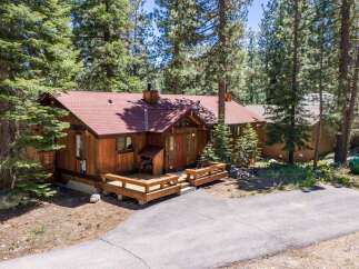 Nestled amongst tall pine trees, this charming wooden cabin offers a serene mountain retreat.
