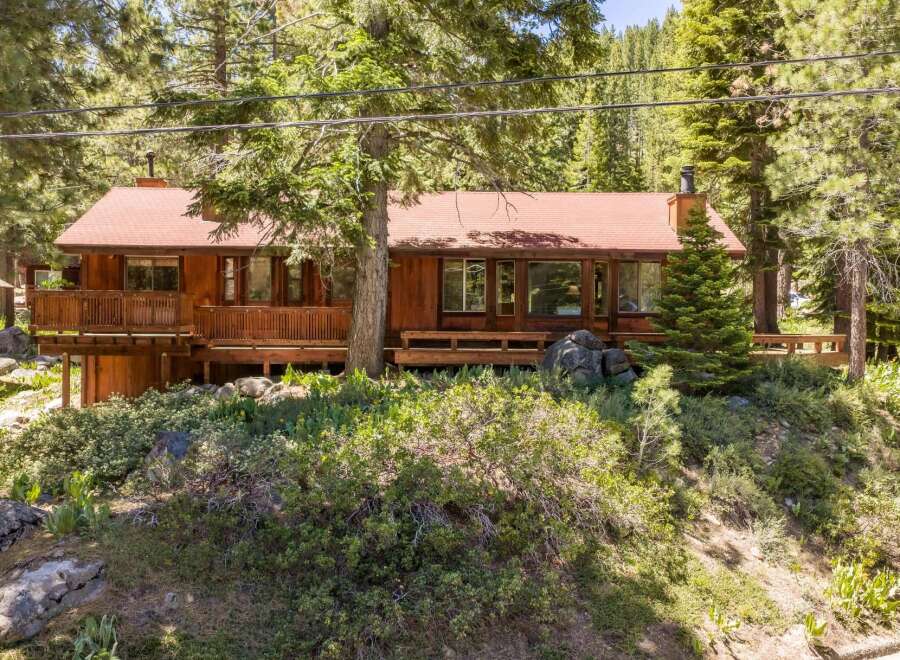Nestled amidst towering pine trees, this charming wooden home offers a serene mountain retreat.