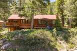 Nestled amidst towering pine trees, this charming wooden home offers a serene mountain retreat.