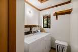 This laundry room features a white top-load washer and dryer set, perfect for handling your household chores.