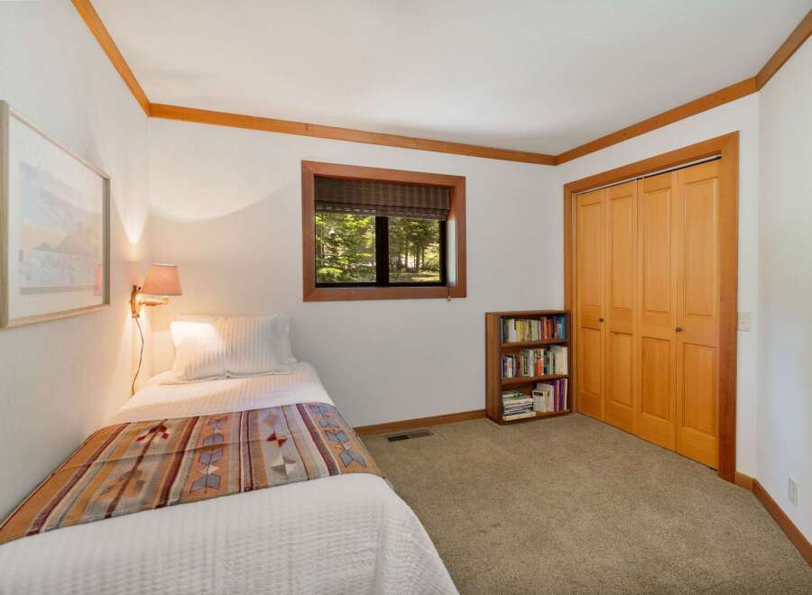This cozy bedroom features a comfortable twin bed adorned with a colorful, patterned throw, perfect for a restful night's sleep.