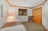 This cozy bedroom features a comfortable twin bed adorned with a colorful, patterned throw, perfect for a restful night's sleep.