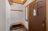 Step into this charming entryway featuring a wooden coat rack and a convenient bench for seating.