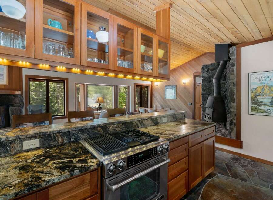 Experience rustic charm in this spacious kitchen featuring a granite-topped island with a built-in gas range, perfect for culinary adventures.