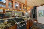 Experience rustic charm in this spacious kitchen featuring a granite-topped island with a built-in gas range, perfect for culinary adventures.