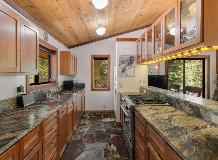Experience rustic charm in this spacious kitchen, featuring warm wooden cabinetry and a stunning granite countertop.