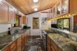 Experience rustic charm in this spacious kitchen, featuring warm wooden cabinetry and a stunning granite countertop.