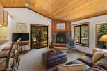 Cozy living room featuring a stone fireplace and a large leather ottoman, perfect for relaxing evenings.