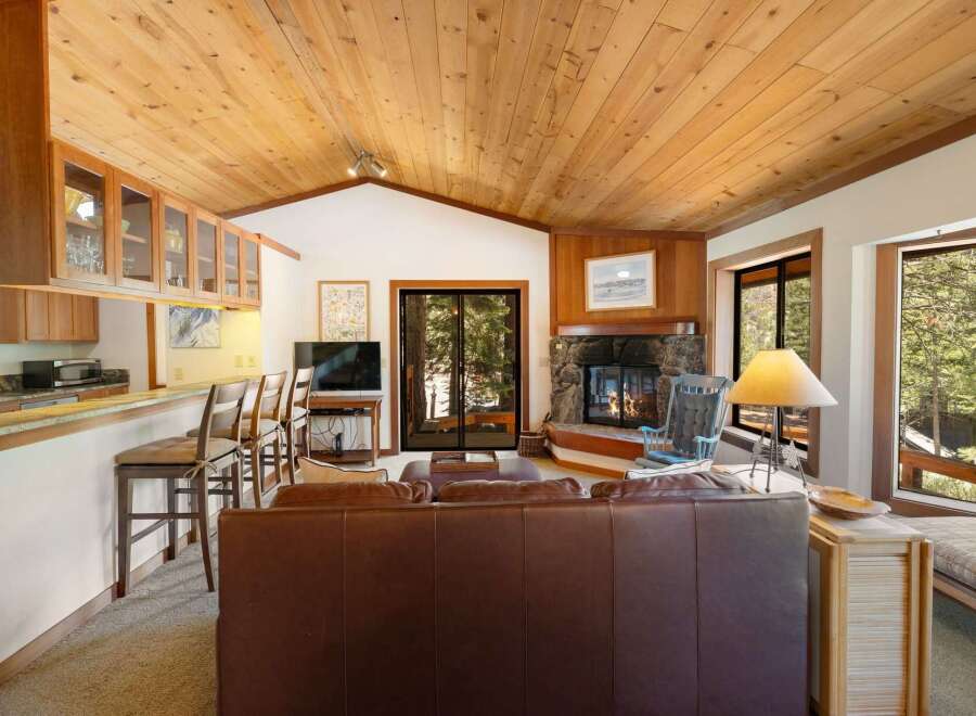 Experience cozy living in this charming mountain retreat, featuring a stunning stone fireplace as the centerpiece of the living area.