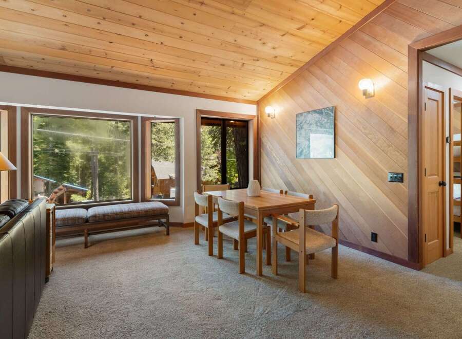 Experience cozy living in this charming dining area, featuring a warm wooden ceiling and accent wall that create a rustic ambiance.