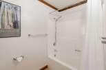 This bathroom features a clean and functional design with a white bathtub and shower combination.