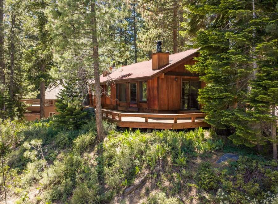 Nestled amidst tall pine trees, this charming wooden cabin offers a serene mountain retreat.