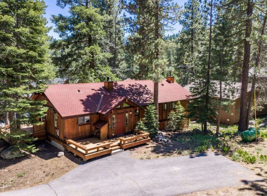 Nestled among tall pine trees, this charming wooden cabin offers a serene mountain retreat.