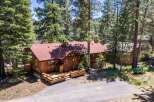 Nestled among tall pine trees, this charming wooden cabin offers a serene mountain retreat.