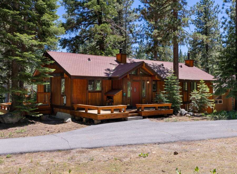 Nestled amidst tall pine trees, this charming wooden cabin offers a serene retreat.