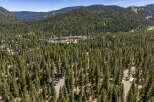 Nestled amidst a dense forest of towering pine trees, this property offers a serene mountain retreat.