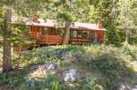 Nestled amidst towering pine trees, this charming wooden cabin offers a serene retreat.