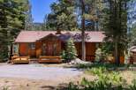 Nestled amongst tall pine trees, this charming wooden cabin offers a serene mountain retreat.