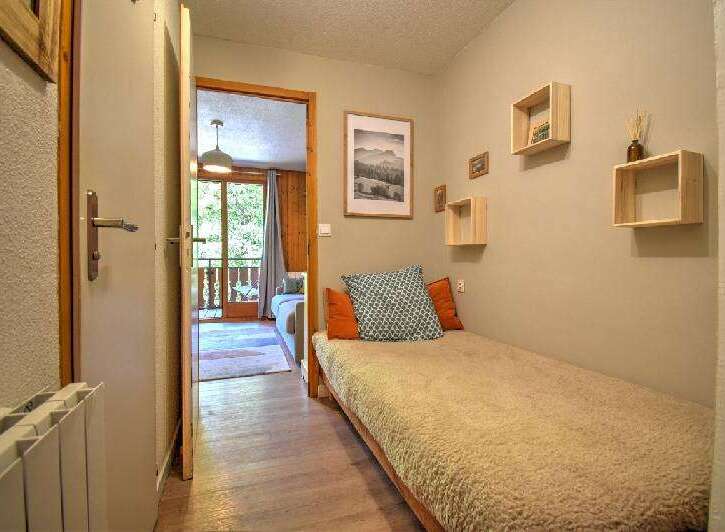 Discover this charming room featuring a cozy single bed adorned with decorative pillows and a plush throw.