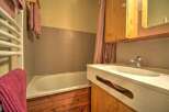 This charming bathroom features a bathtub with tiled walls and a wooden base, perfect for a relaxing soak.