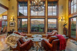 Experience luxury mountain living in this stunning great room, featuring plush leather armchairs and a cozy fur throw perfect for relaxing evenings.