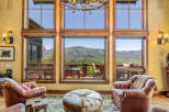 Experience breathtaking mountain views from this stunning living room, featuring expansive windows that flood the space with natural light.