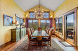 Experience breathtaking mountain views from this elegant dining room, featuring a grand crystal chandelier and a rustic wooden table set for intimate gatherings.