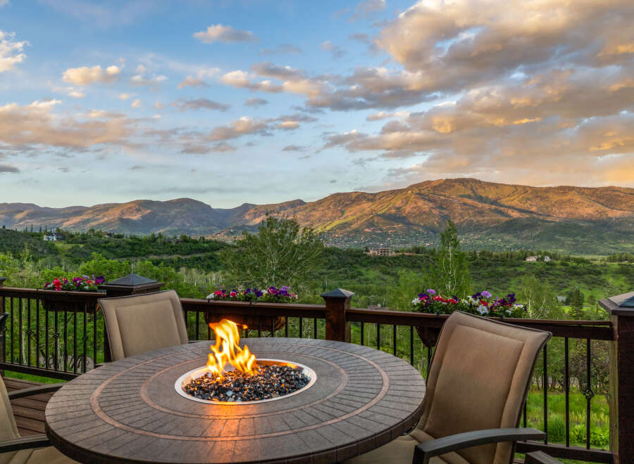 Experience breathtaking mountain views from this stunning deck, complete with a cozy fire pit and comfortable seating.
