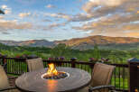 Experience breathtaking mountain views from this stunning deck, complete with a cozy fire pit and comfortable seating.