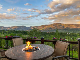 Experience breathtaking mountain views from this stunning deck, complete with a cozy fire pit and comfortable seating.