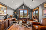 Experience rustic elegance in this executive office, featuring a grand wooden desk and plush leather chairs.