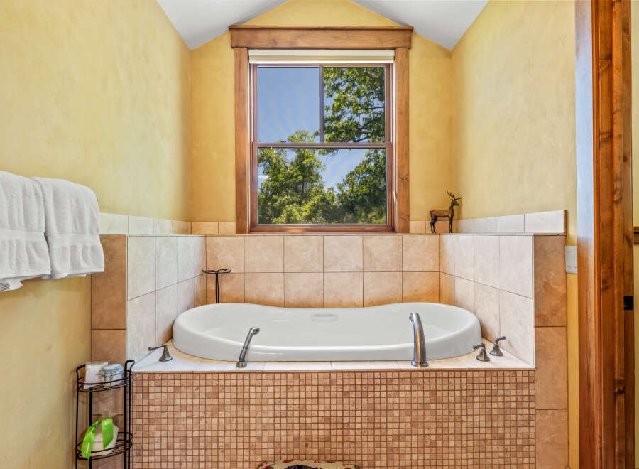 Indulge in relaxation in this luxurious bathroom featuring a deep soaking tub, perfect for unwinding after a long day.