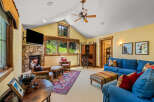 Cozy living room featuring a stone fireplace and large windows with scenic views.