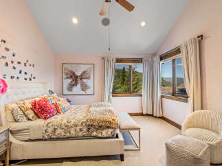 Experience serene mountain living in this charming bedroom, featuring a plush king-sized bed adorned with decorative pillows and a cozy throw.