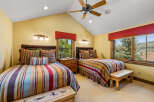 This charming bedroom features two comfortable beds adorned with vibrant, striped bedding and decorative pillows.