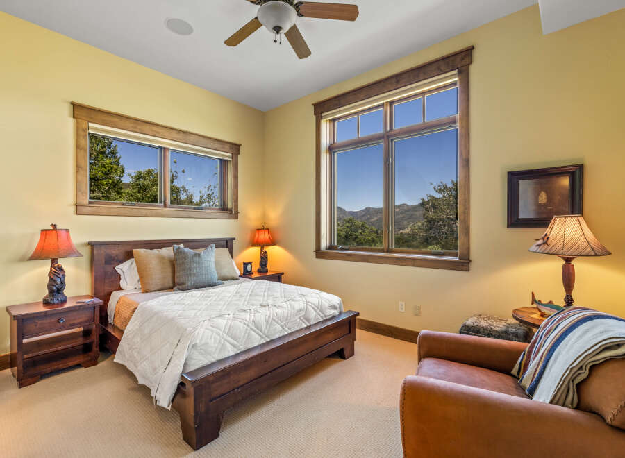Experience rustic charm in this cozy bedroom, featuring a comfortable wooden bed and a plush armchair perfect for relaxation.