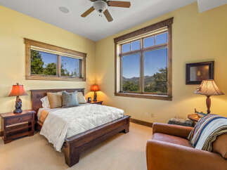 Experience rustic charm in this cozy bedroom, featuring a comfortable wooden bed and a plush armchair perfect for relaxation.