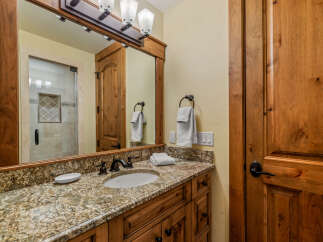 This bathroom showcases a beautiful granite countertop with an undermount sink and oil-rubbed bronze fixtures.