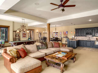 This spacious basement living area offers a perfect blend of entertainment and relaxation, featuring a full-size pool table and a cozy sectional sofa.