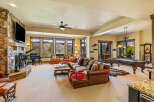 Experience luxury mountain living in this spacious great room, featuring a grand piano, a large stone fireplace, and a pool table for entertainment.