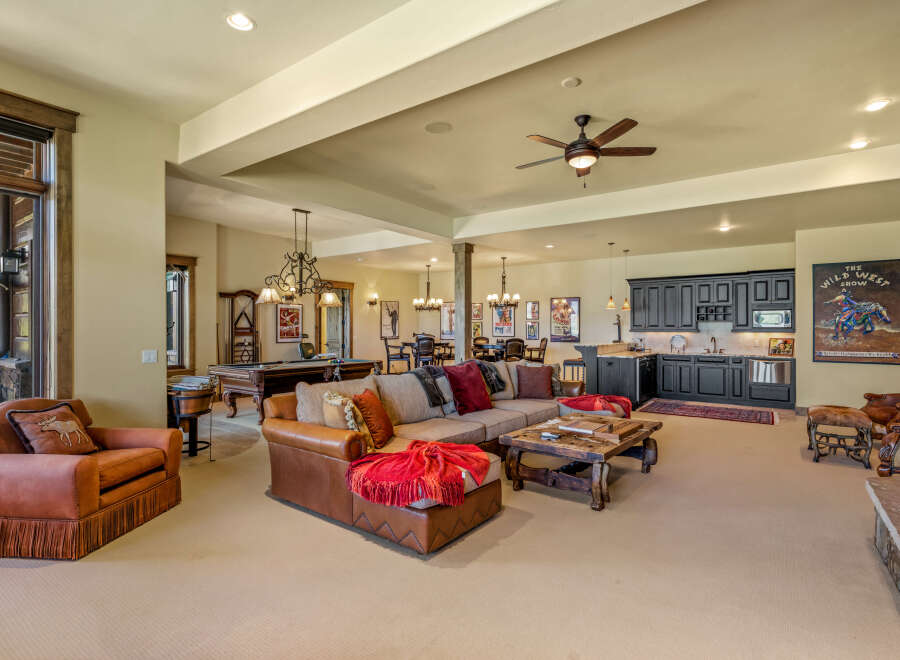 This spacious entertainment area features a large sectional sofa, a pool table, and a full bar with a microwave and mini-fridge.