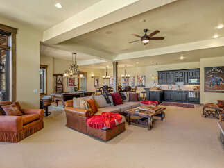 This spacious entertainment area features a large sectional sofa, a pool table, and a full bar with a microwave and mini-fridge.