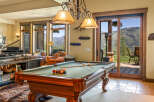 Experience luxury mountain living in this stunning home featuring a spacious game room with a billiards table, perfect for entertaining.