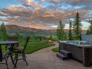 Experience luxury outdoor living with this stunning property featuring a relaxing hot tub and a cozy fire pit, perfect for enjoying breathtaking mountain views.